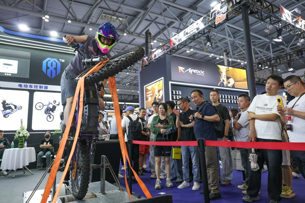 2025年9月，观众在重庆摩博会现场体验国产新能源摩托车控制器自动翘头功能。新华社记者 陈诚 摄 
