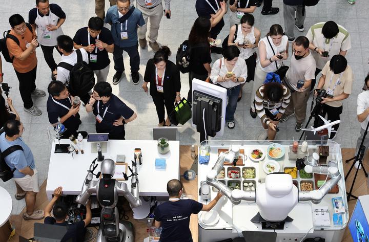 图为7月17日,参观者在世博展览馆内观看机器人技能展示。新华社记者方喆 摄